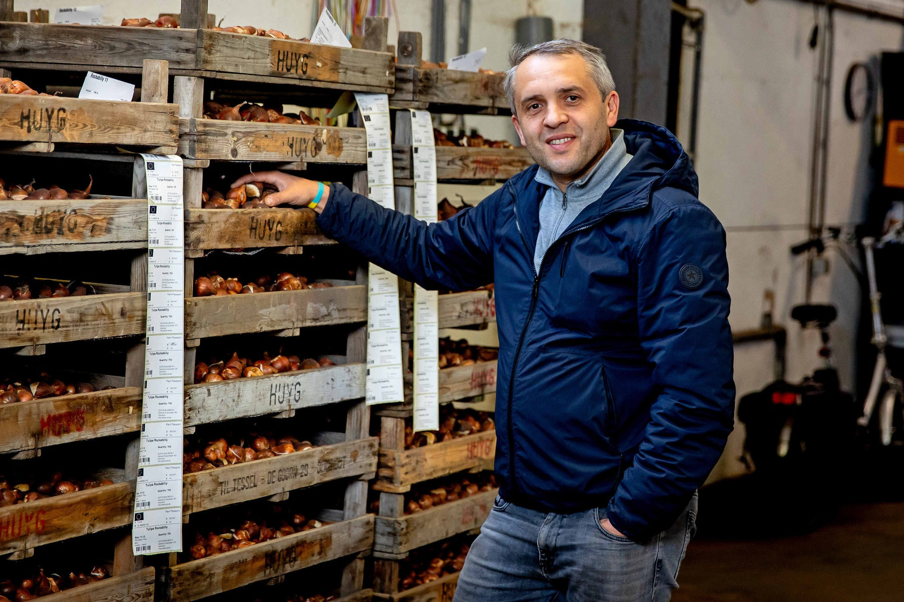 Vitaliy Tonenchuk accanto a cassette di bulbi da fiore